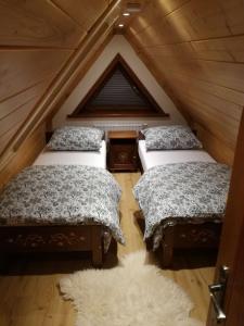 a attic room with two beds and a rug at aPARTAMENT Osada Za Torem in Ciche
