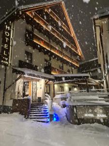 a building in the snow with a pile of snow at Hotel Raibl e Appartamenti in Tarvisio