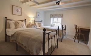 a bedroom with two beds and a desk in it at Carlton Cottage, Castleton in Castleton