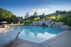 una gran piscina con una pared de retención de rocas en Hotel Le Grotte en Genga