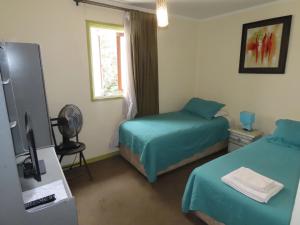 a hotel room with two beds and a television at Hotel Baleares in Santiago