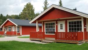 een rood huis met een witte deur en ramen bij Beverøya Hytteutleie og Camping in Bø