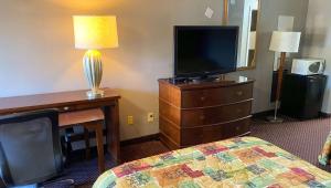 a hotel room with a bed and a tv and a desk at Magnuson Hotel Marietta in Marietta