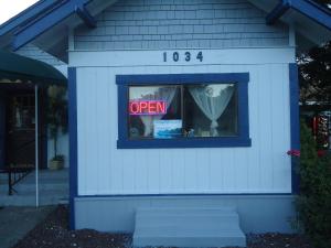 una casa con una señal abierta en una ventana en Blue Mountain Motel, en Okanogan