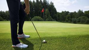 una persona está jugando al golf en un campo de golf en Magnuson Extended Stay and Suites Airport Hotel, en Irving