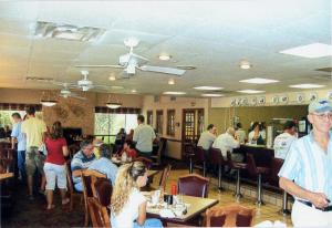 a group of people sitting at tables in a restaurant at Will Rogers Inn in Claremore