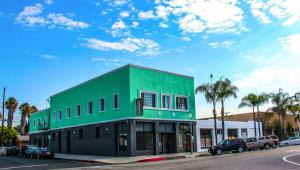 a green building on the side of a street at Plaza Hotel Gardena in Gardena