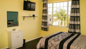 a bedroom with a bed and a sink and a window at Plaza Hotel Gardena in Gardena