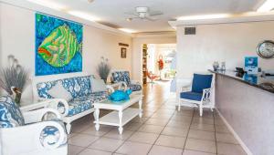 una sala de estar con muebles azules y blancos y una pintura en Belleair Beach Resort Motel, en Clearwater Beach