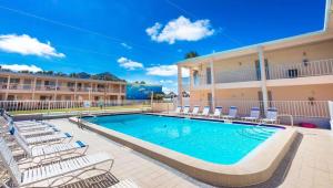 a swimming pool with chairs and a hotel at Belleair Beach Resort Motel in Clearwater Beach