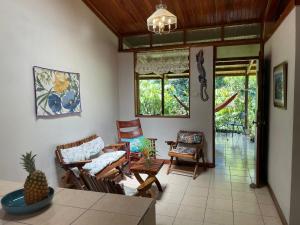 a living room with chairs and a table at Finca Isla Rainforest Retreat in Aguas Zarcas