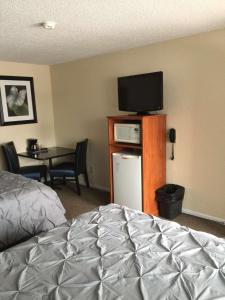 a bedroom with a bed and a television and a table at Custom Stay Thief River Falls in Thief River Falls
