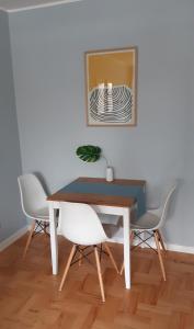 a dining room table with two chairs and a mirror at Apartament Pod Lasem in Gdańsk