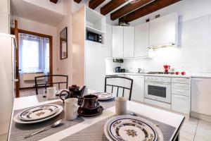 uma cozinha com uma mesa com pratos em San Marco - 2 bedrooms with lift em Veneza