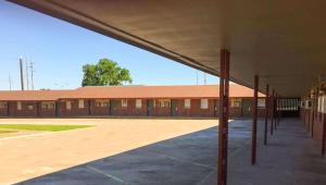 an empty school building with a empty parking lot at Budget Inn Ardmore OK in Ardmore