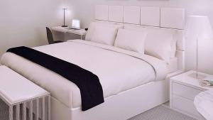 une chambre blanche avec un lit blanc et un bureau dans l'établissement Sun Plaza Motel, à Silver Springs