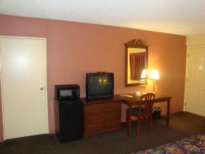 ウィルミントンにあるWilmington Innのデスク、テレビ、テーブルが備わる客室です。