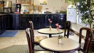 twee tafels en stoelen met bloemen erop in een restaurant bij Gray Inn & Suites in Gray
