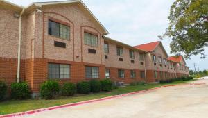 un gran edificio de ladrillo con muchas ventanas en Magnuson Hotel Cedar Hill en Cedar Hill