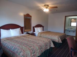 Huggy Bear Motel - Warren في Warren: غرفة فندقية بسريرين ومرآة
