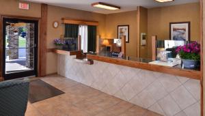 a hair salon with a reception counter and flowers at Magnuson Hotel Country Inn in Ishpeming