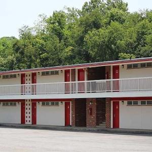 a red and white building with a balcony at Hometown Inn Staunton in Greenville