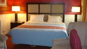 a bedroom with a large bed and two chairs at New Haven Inn in New Haven