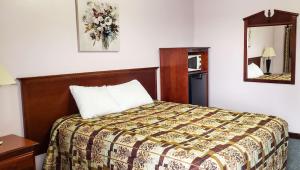 a hotel room with a bed and a mirror at Windmill Inn Lynden in Lynden