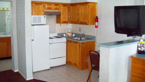 a kitchen with a white refrigerator and a sink at Blue Mist Motel Florence in Florence