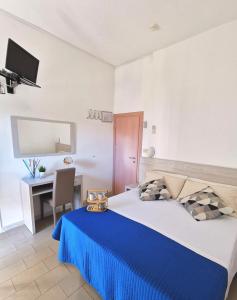 sypialnia z dużym łóżkiem i niebieskim kocem w obiekcie Hotel Bellini w mieście Riccione