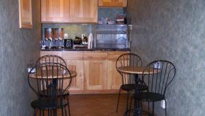 una cocina con 2 mesas y 2 sillas y una barra en Magnuson Hotel Ely, en Ely