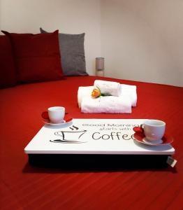 - un plateau avec 2 tasses et une pancarte à café sur le lit dans l'établissement A Ca di Piè, à Arcola