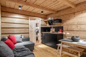 a living room and kitchen in a log cabin with a couch at APARTAMENTY DVOOR1924 in Poronin