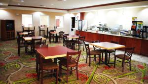 un restaurante con mesas y sillas y una cocina en Magnuson Hotel Commerce en Commerce