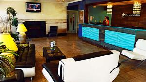 un vestíbulo con un bar con muebles blancos y una mujer en Magnuson Hotel & Marina New Port Richey, en New Port Richey