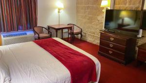 a hotel room with a bed and a flat screen tv at Voyageur Inn and Conference Center in Reedsburg