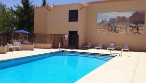 a swimming pool with chairs and a building with a painting at Ticaboo Lodge in Ticaboo