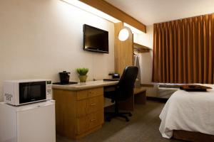 Mountain Home Inn في ماونتن هوم: غرفة في الفندق مع مكتب مع ميكروويف وسرير