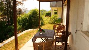 una mesa al aire libre con una sombrilla en el patio en Sonnige 2-Zimmer Wohnung mit Terrasse und Garten, en Nagold