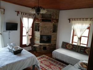 1 Schlafzimmer mit 2 Betten und einem Steinkamin in der Unterkunft MEGLEN KONAK in Sirince