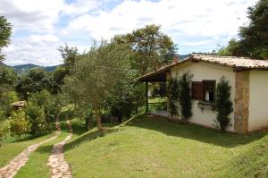 ein kleines Haus auf einem Hügel neben einem Hof in der Unterkunft Chalés de Minas Hotel Fazenda in Caxambu
