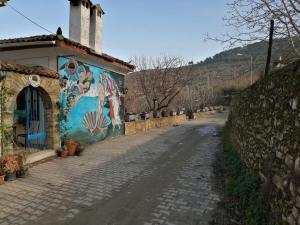 une rue avec une fresque murale sur le côté d'un bâtiment dans l'établissement MEGLEN KONAK, à Sirince