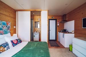 a bedroom with a large bed and a kitchen at Calheta Glamping Pods - Nature Retreat in Calheta