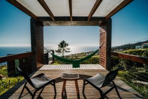 Habitación con hamaca y terraza con sillas. en Calheta Glamping Pods - Nature Retreat, en Calheta