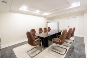 une salle de conférence avec une table et des chaises dans l'établissement Tantana Hotel, à Ferghana