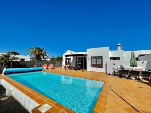 a villa with a swimming pool in front of a house at Villa Pilar in Playa Blanca