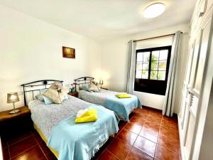 a bedroom with two beds and a window at Villa Pilar in Playa Blanca +23 photos