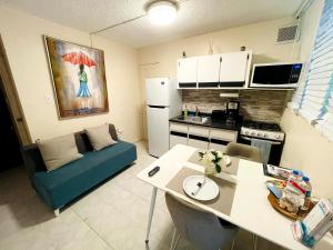 eine Küche mit einem blauen Sofa und einem Tisch in einem Zimmer in der Unterkunft Homey Escape with Patio Access and FREE laundry in Ponce