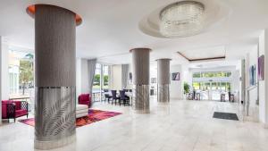 a lobby with columns and chairs and a chandelier at YVE Hotel Miami in Miami