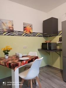 eine Küche mit einem Tisch mit Stühlen und einer Mikrowelle in der Unterkunft Ferienwohnung "An der Geest 1" in Buxtehude
